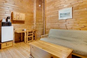 een slaapkamer met een bed, een koelkast en een bureau bij Ingonish Chalets in Ingonish Beach