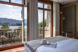 een slaapkamer met een bed en een groot raam bij La Réserve Eden au Lac Zurich in Zürich