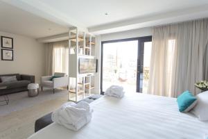 1 dormitorio con 1 cama blanca grande y sala de estar en Hotel Almirante en Alicante