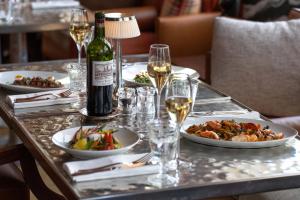 een tafel met borden en glazen wijn bij La Réserve Eden au Lac Zurich in Zürich