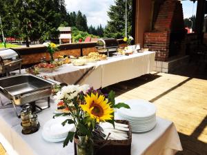 un tavolo con piatti e fiori su un patio di Club Rossignol a Poiana Brasov