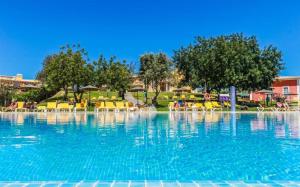 - une piscine dans un complexe avec des chaises et des arbres dans l'établissement Colina da Lapa & Villas, à Carvoeiro