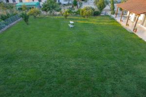 a green yard with a bird sitting in the grass at Nicole Fresh Apartments in Keramotí