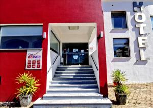 um edifício vermelho e branco com escadas que levam a uma porta em Casa Do Vale Hotel em Évora