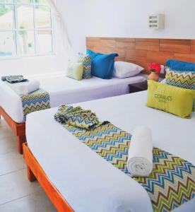 a group of three beds in a room at Corales Suites in Puerto Morelos