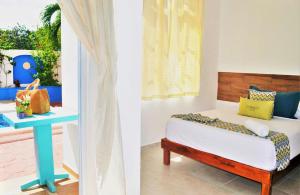 two images of a bedroom with a bed and a table at Corales Suites in Puerto Morelos