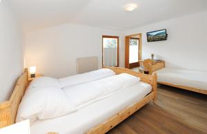 1 dormitorio con 2 camas con sábanas blancas en Chalet Gloria - Doppel- und Mehrbettzimmer, en Bruck an der Großglocknerstraße