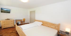 1 dormitorio con 1 cama, 1 mesa y 1 silla en Chalet Gloria - Doppel- und Mehrbettzimmer, en Bruck an der Großglocknerstraße