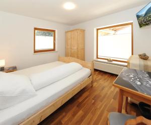 1 dormitorio con 1 cama grande y escritorio en Chalet Gloria - Doppel- und Mehrbettzimmer, en Bruck an der Großglocknerstraße