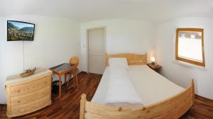 1 dormitorio con cama de madera y escritorio en Chalet Gloria - Doppel- und Mehrbettzimmer, en Bruck an der Großglocknerstraße