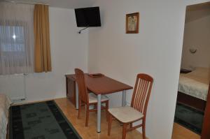 a room with a table and two chairs and a bed at Penzion Kmečki Hram in Ljubljana