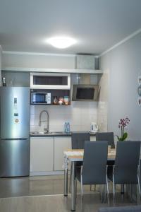 een keuken met een tafel en een roestvrijstalen koelkast bij Dream Apartment in Suwałki