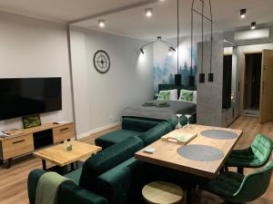 ein Wohnzimmer mit einem grünen Sofa und einem Tisch in der Unterkunft Marina Green Loft-Apartament przy promenadzie in Lyck