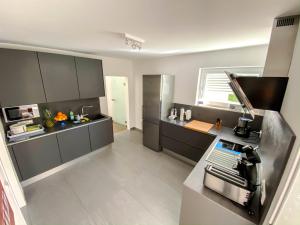 una cucina con armadi grigi e piano di lavoro di Apartment Schanzenstraße 690 m ü. M a Winterberg