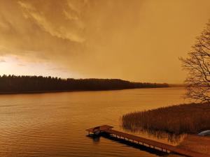 een dok op een waterlichaam met een zonsondergang bij Apartamenty Mazurskie Klimaty (Cud Natury) in Tomaszkowo