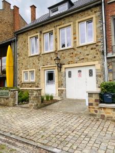 een stenen huis met twee witte garagedeuren bij Avenue Rops in Namen