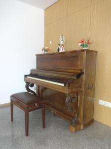 un piano brun avec un tabouret à côté dans l'établissement Hotel Bonjardim, à Tomar