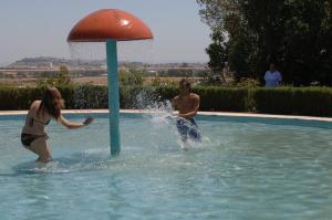 un hombre y una mujer jugando en una piscina en Elxadai Parque, en Elvas