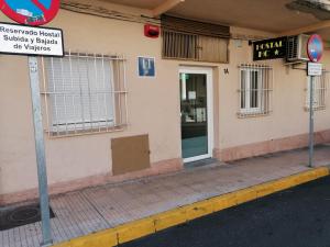 Hostal Hernan Cortes في قصرش: مبنى عليه لافته على جانب شارع