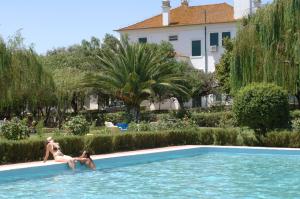 dos personas están sentadas en una piscina en Elxadai Parque, en Elvas