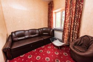 a living room with a leather couch and a chair at Mini Hotel Smak in Dnipro