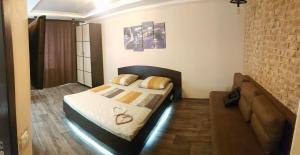 um pequeno quarto com uma cama e um sofá em Apartment new 95 Kvartal em Kryvyi Rih