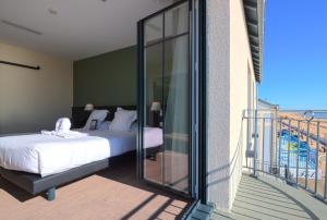 een slaapkamer met een bed en een balkon bij Les Flots - Hôtel et Restaurant face à l'océan - Châtelaillon-Plage in Châtelaillon-Plage