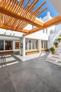 a large outdoor patio with a wooden pergola at Rochari Hotel in Mýkonos City