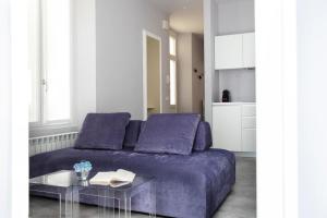 uma sala de estar com um sofá roxo e uma mesa em Residenza Porto Vecchio em Luino