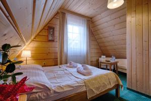 - une chambre avec un lit dans une pièce en bois dans l'établissement Góralski Gościniec & SPA, à Poronin