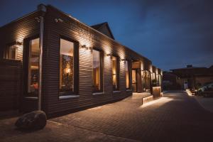 een houten gebouw met ramen in de nacht bij Hotel Hildebrandt's in Neumünster