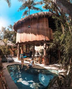 a hut with a swimming pool in a resort at Gili Treehouse in Gili Trawangan