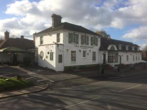 un edificio blanco en la esquina de una calle en The Wheatsheaf Inn, en Cuckfield