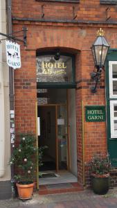 ein Backsteingebäude mit Hoteleingang und Schild in der Unterkunft HOTEL alt lüneburger Kutscherstuben in Lüneburg