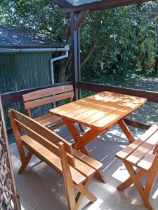 un tavolo da picnic in legno e 2 panche su una terrazza di Borostyán Vendégház Dunasziget a Dunasziget