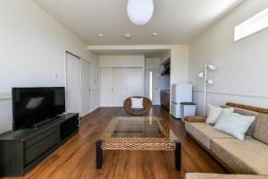 a living room with a couch and a tv at Odysis Onna Resort Hotel in Onna