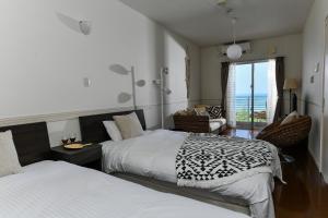 a bedroom with two beds and a view of the ocean at Odysis Onna Resort Hotel in Onna