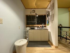 een kleine keuken met een toilet en een wastafel bij mooi guesthouse 日新町 in Aizuwakamatsu