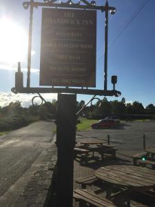 een bord voor de shambhock Inn met picknicktafels bij The Shandwick Inn in Tain