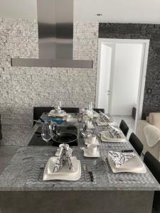 une salle à manger avec une table, des assiettes et des verres dans l'établissement Swiss Luxury Apartment, à Mosonmagyaróvár