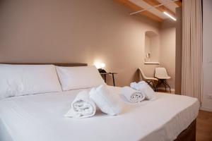 ein Schlafzimmer mit einem weißen Bett und Handtüchern darauf in der Unterkunft Tergestroom & boutique apartments in Triest