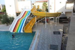 - un toboggan dans une piscine avec une personne dans l'eau dans l'établissement Gül Otel, à Belek