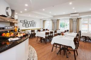 a restaurant with white tables and chairs in a room at Hotel Löwen am See in Zug