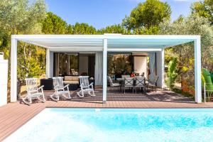 una terraza con mesa y sillas junto a una piscina en Fazenda Viegas, en Lagos