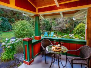 eine Veranda mit einem Tisch und Stühlen darauf in der Unterkunft Volcano Teapot Cottage in Volcano