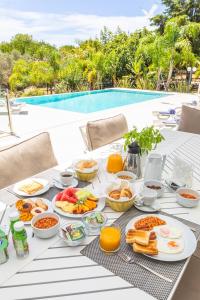 una mesa con desayuno junto a una piscina en Fazenda Viegas, en Lagos