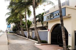 ein Hotel mit Palmen vor einem Gebäude in der Unterkunft Airport Hotel Casino du Cap-vert in Dakar