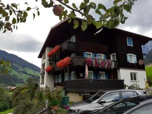 un edificio con fiori sui balconi e un'auto di Gästehaus Sahler a Gaschurn