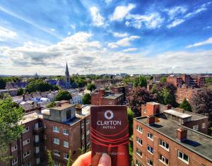 uma pessoa segurando uma lata de coliton em frente a uma cidade em Clayton Hotel Burlington Road em Dublin