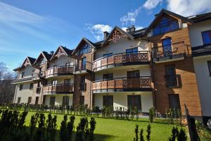 un immeuble d'appartements avec balcon et cour dans l'établissement Apartamenty Forma Tatrica, à Zakopane